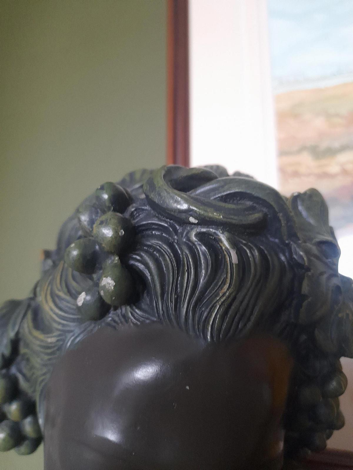 Plaster bust and shoulders of a young woman.