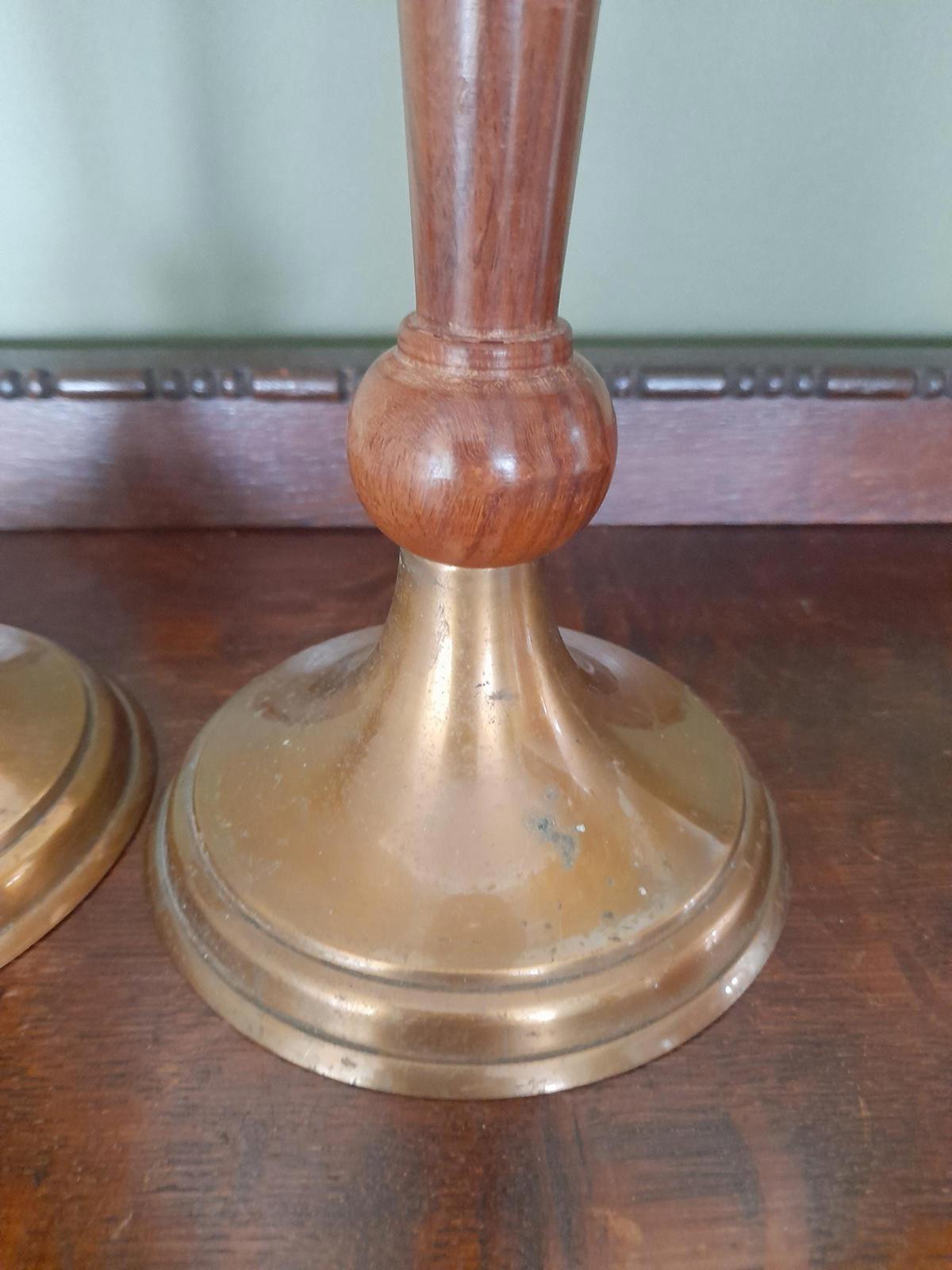 A pair of brass and dark wood tall candle holders