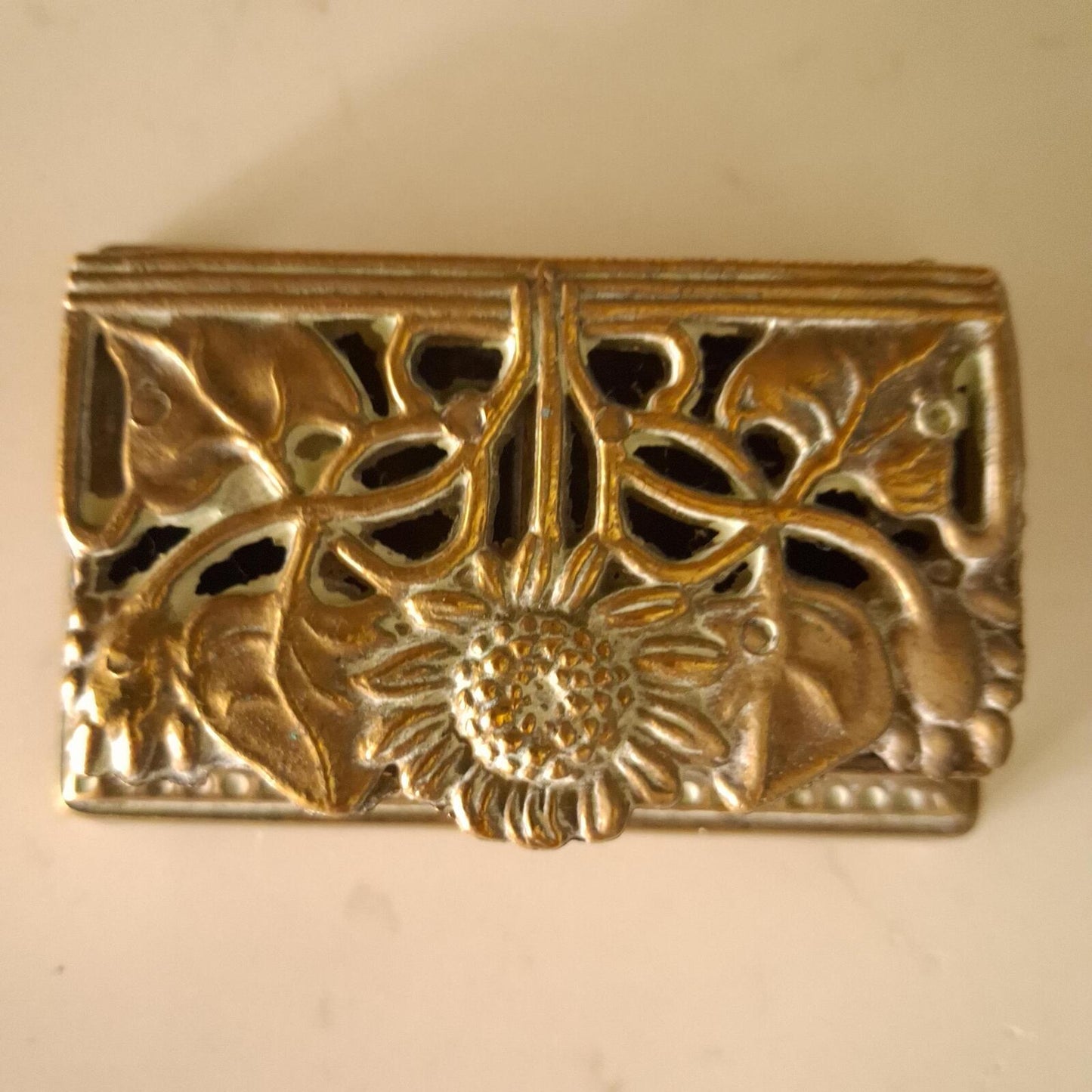 A brass sunflower design brass stamp holder
