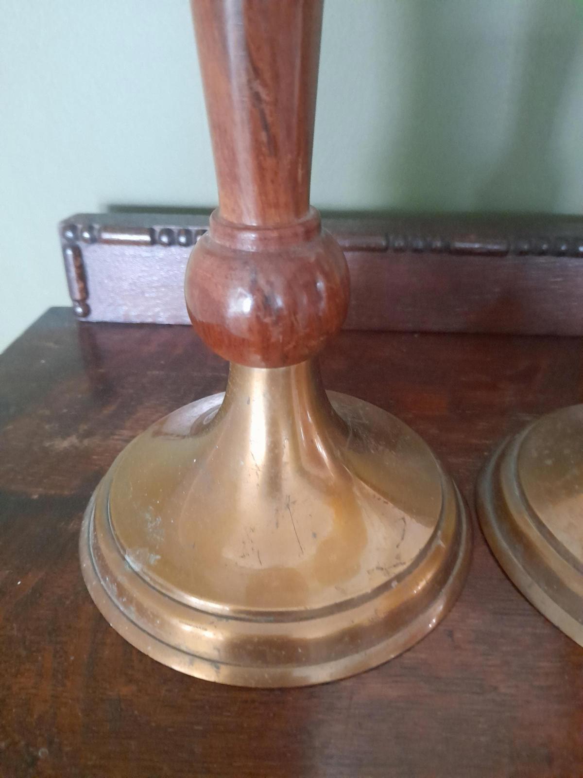 A pair of brass and dark wood tall candle holders