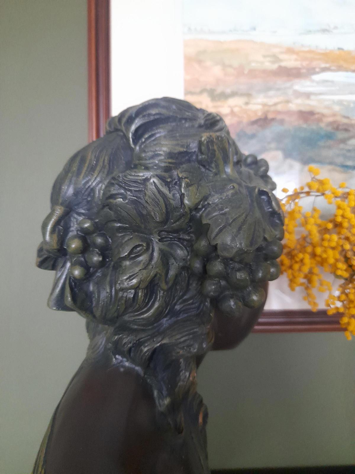Plaster bust and shoulders of a young woman.