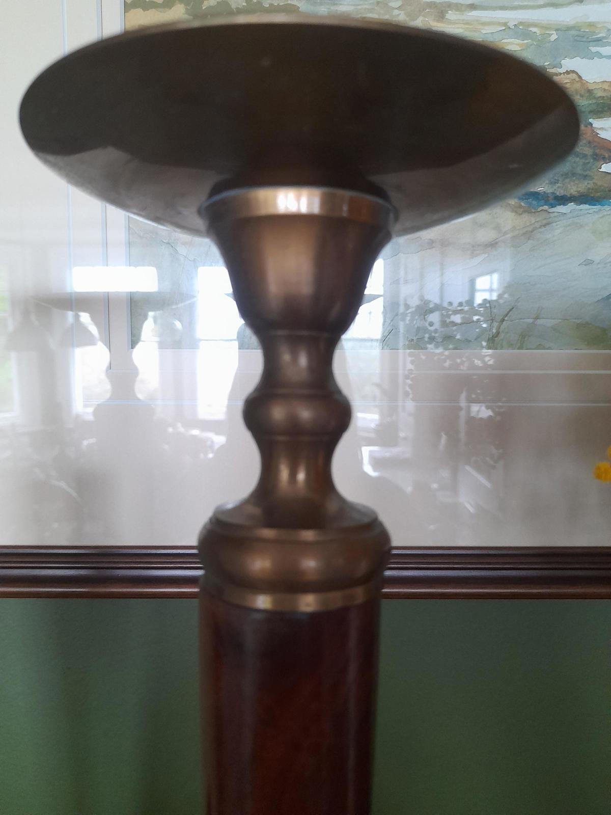 A pair of brass and dark wood tall candle holders