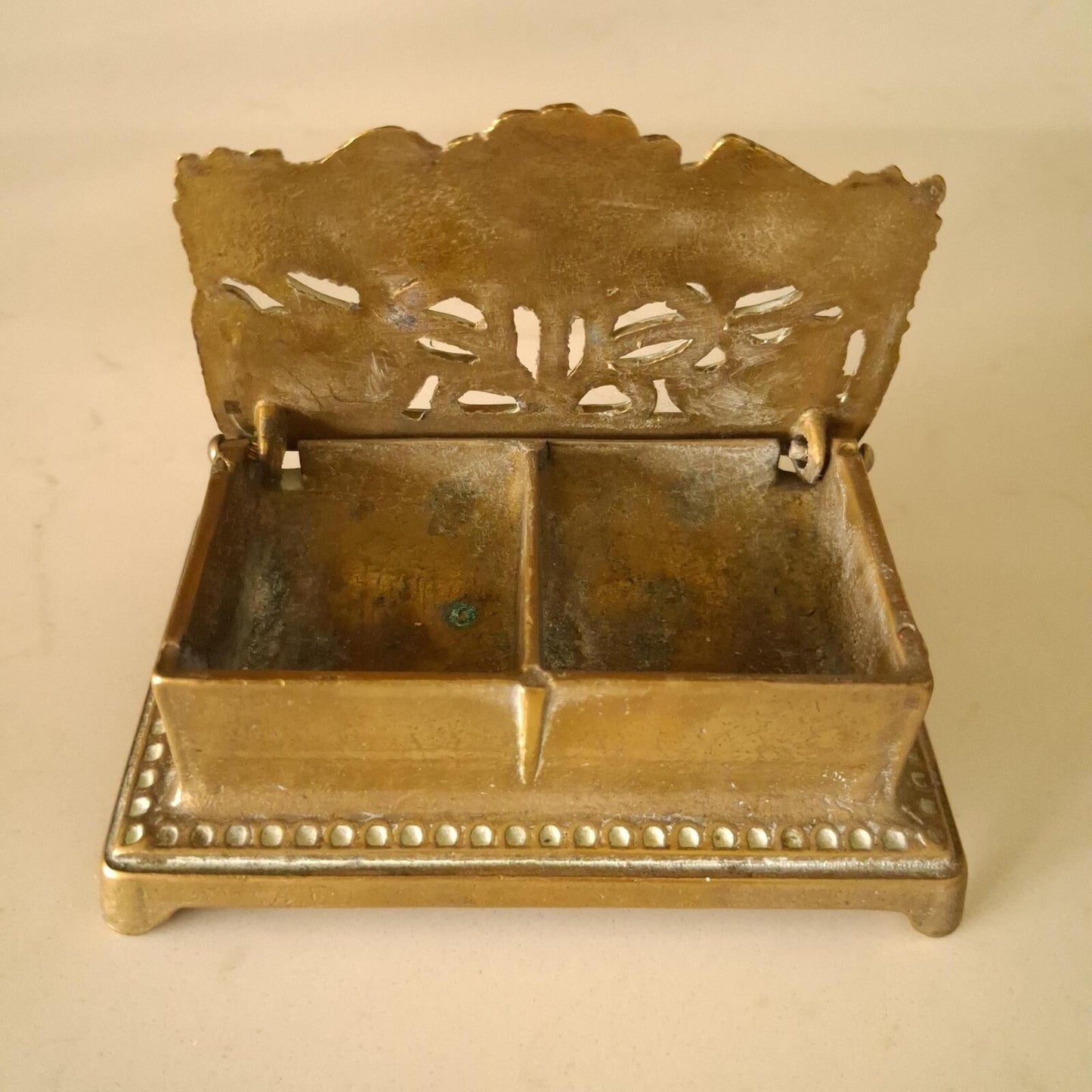 A brass sunflower design brass stamp holder