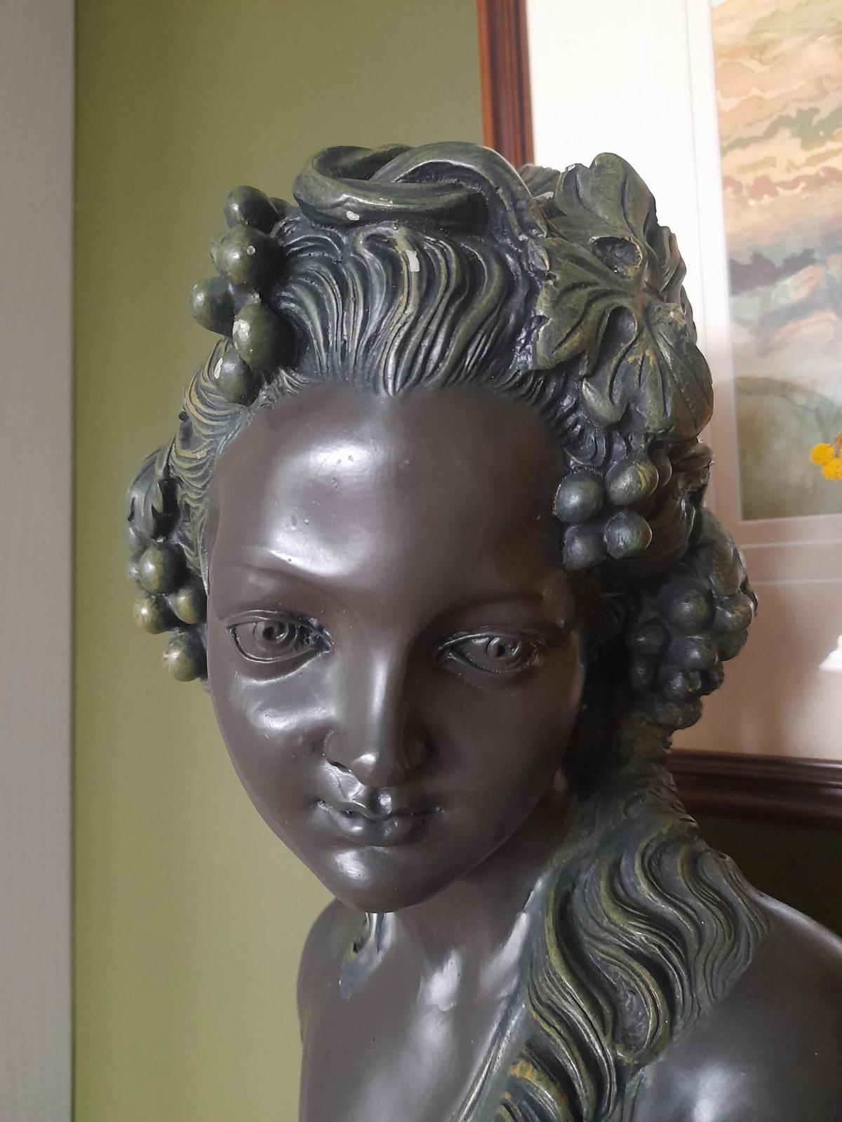 Plaster bust and shoulders of a young woman.