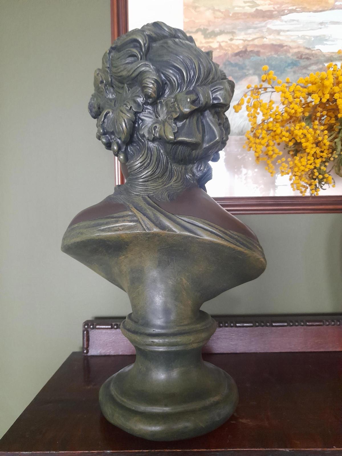 Plaster bust and shoulders of a young woman.