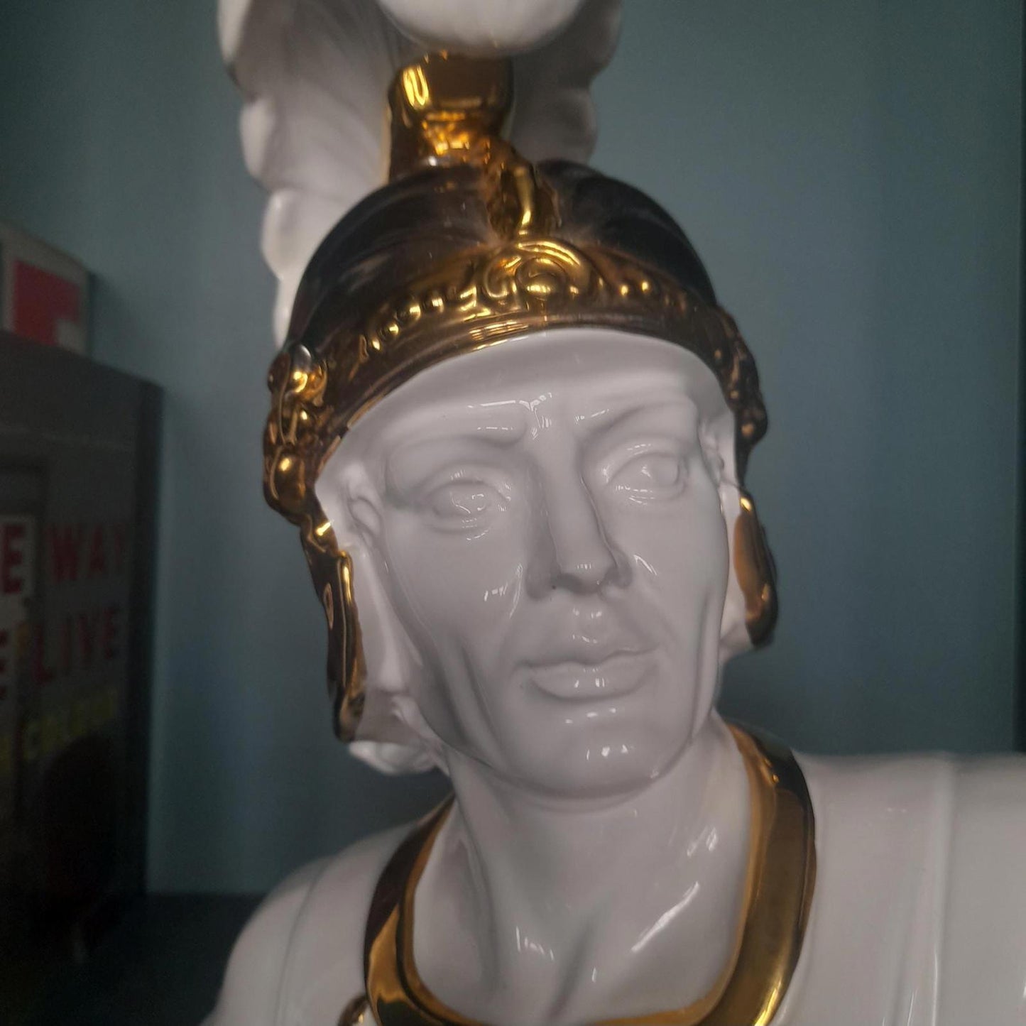 White ceramic bust of a gladiator with gold accents