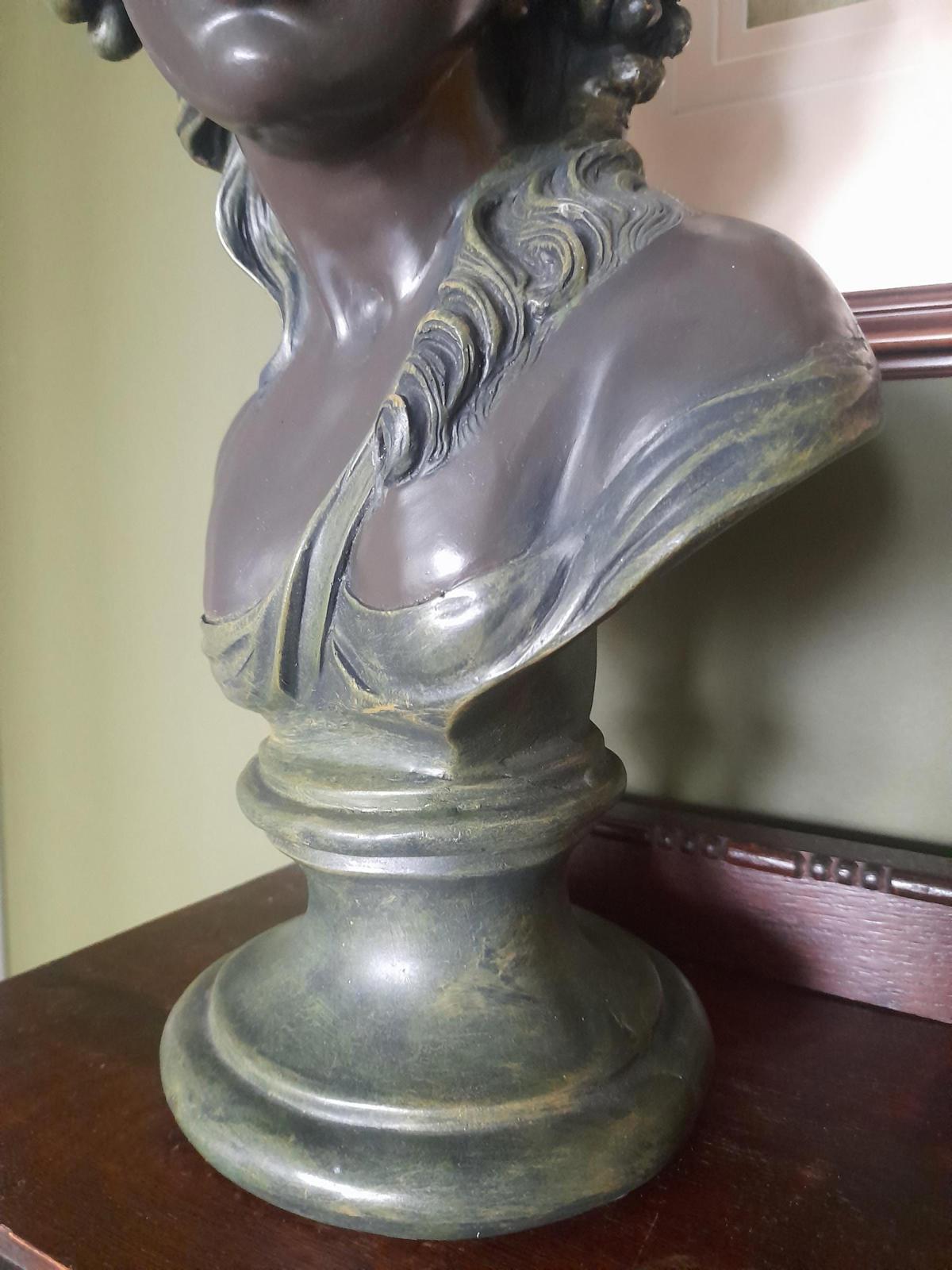 Plaster bust and shoulders of a young woman.