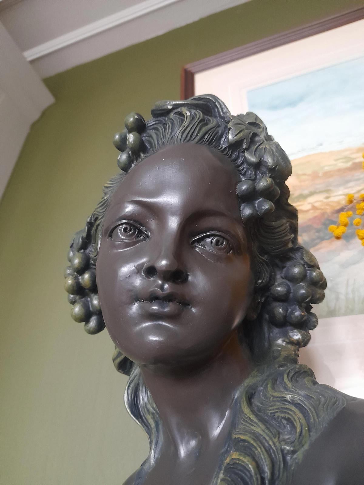 Plaster bust and shoulders of a young woman.