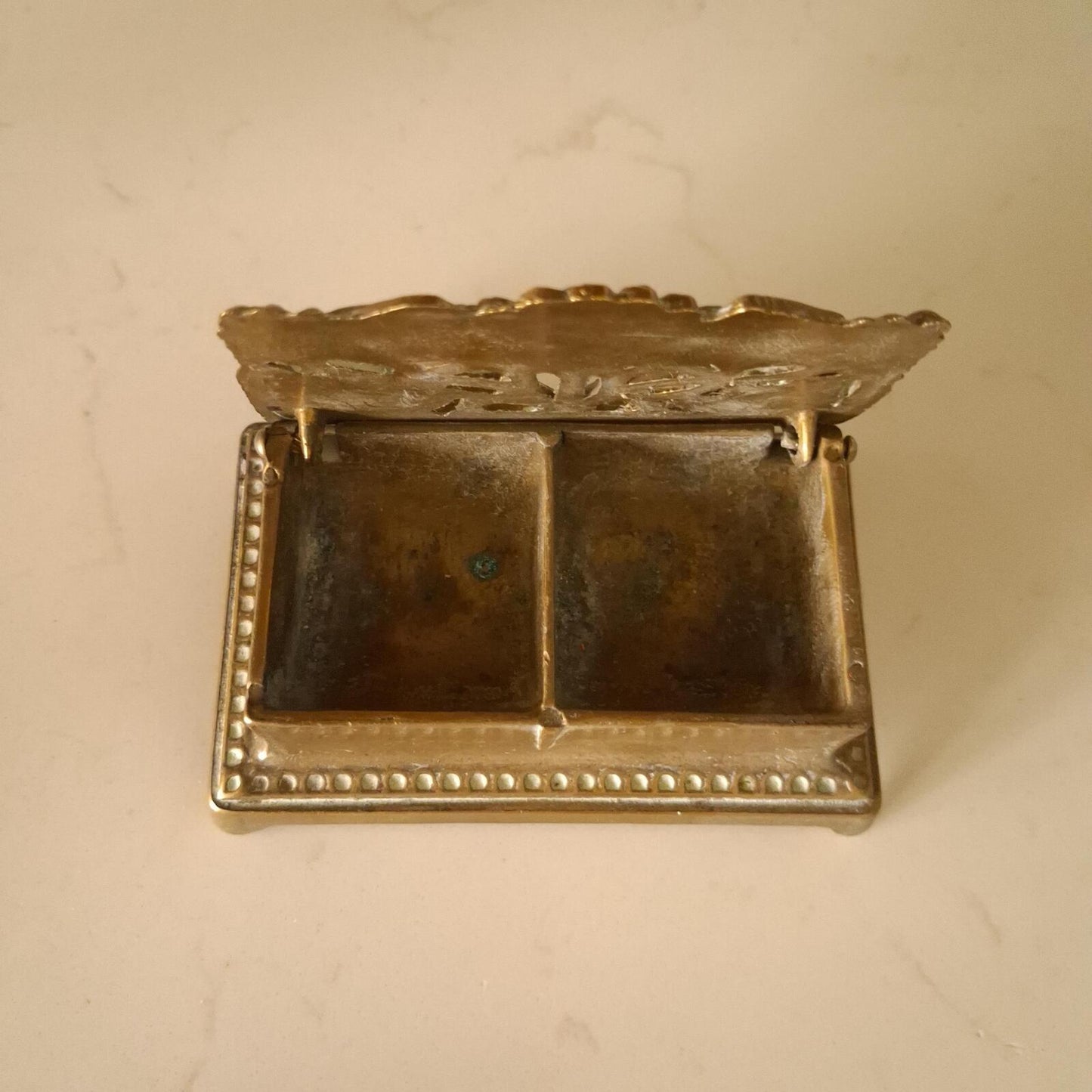 A brass sunflower design brass stamp holder