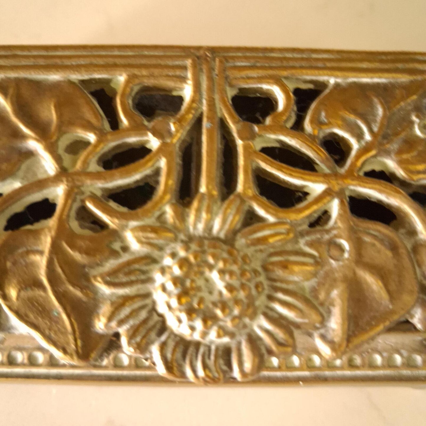 A brass sunflower design brass stamp holder